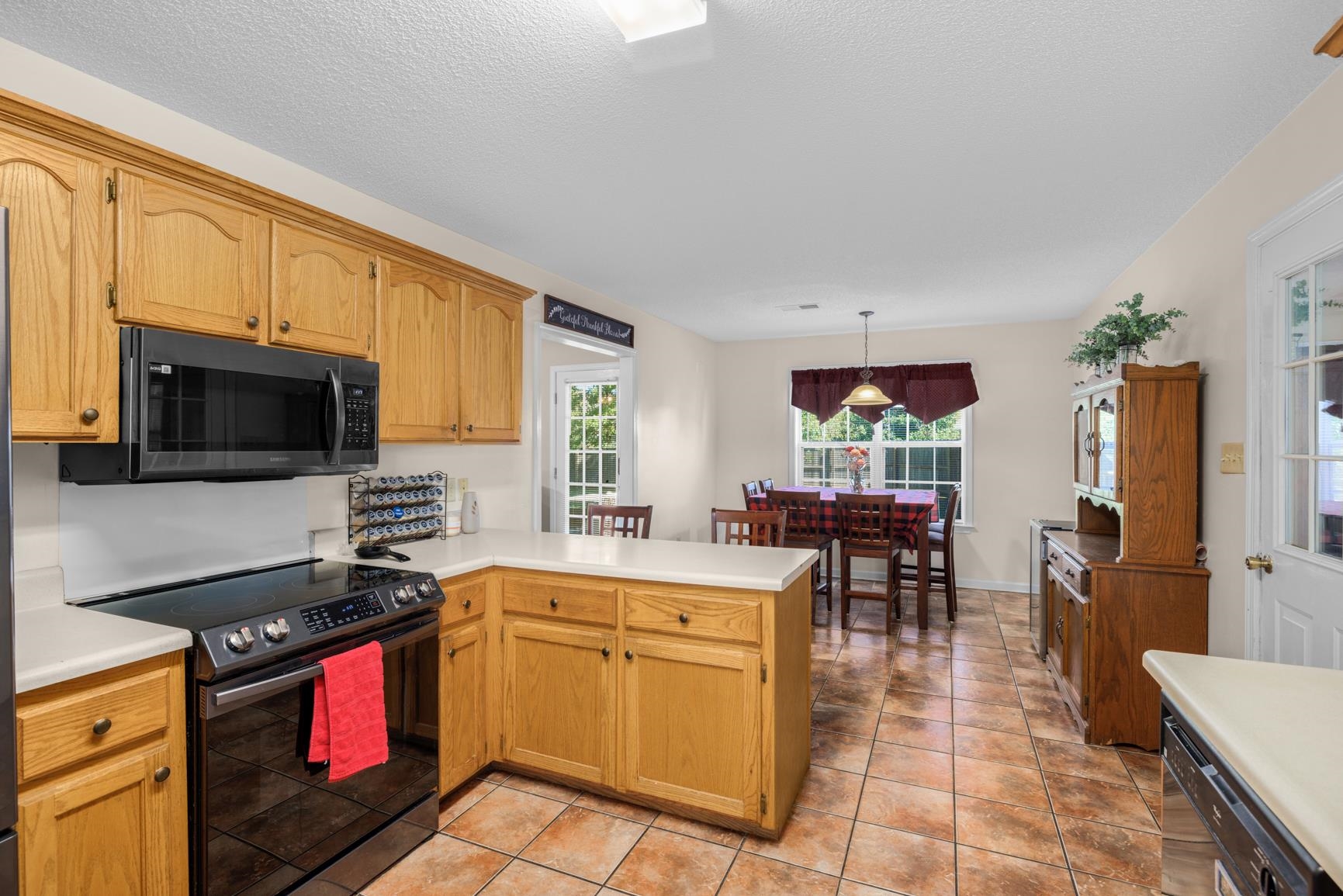 538 Rosemark Road Atoka, TN 38004 - Photo 15 of 25 a kitchen with stainless steel appliances granite countertop a stove top oven a sink a dining table and chairs with wooden floor