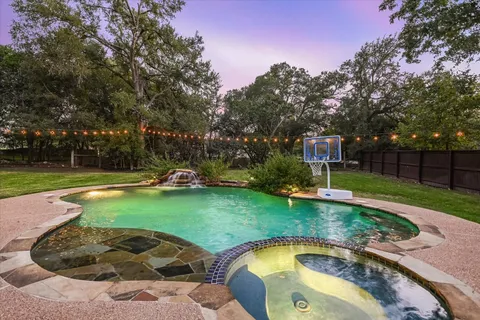 a view of a yard with a table and chairs under an umbrella