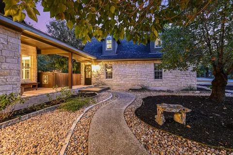 a view of a backyard with plants and large tree