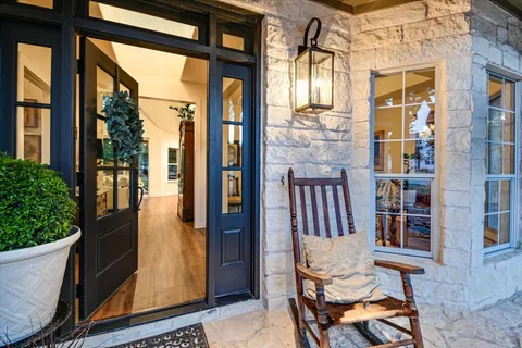 a view of a balcony with chairs and a potted plant