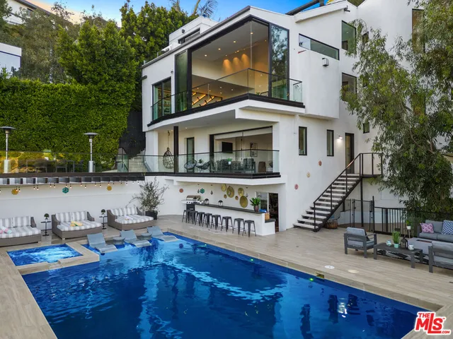 a view of a house with pool and sitting area