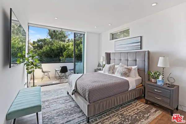 a bedroom with a bed wooden floor and window