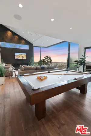 a view of a kitchen with stainless steel appliances dining table chairs and a large window