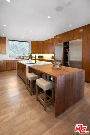 a large dining hall with stainless steel appliances granite countertop a barbecue counter and chairs