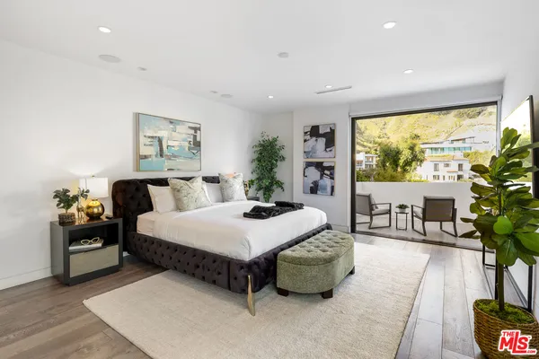 a spacious bedroom with a bed and a large window