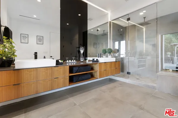 a spacious bathroom with a double vanity sink mirror and shower