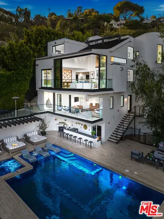 a front view of a house with swimming pool and outdoor seating