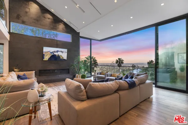 a living room with furniture and a floor to ceiling window