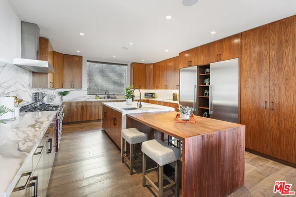a large kitchen with cabinets table and chairs