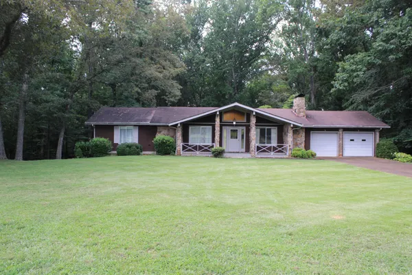 a view of a house with a yard and sitting area