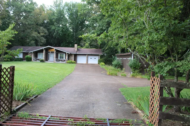 a front view of a house with a yard and trees