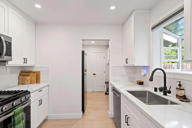 a kitchen with a sink cabinets a stove and a refrigerator
