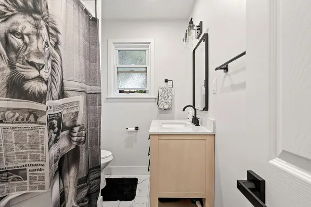 a bathroom with a sink toilet and mirror