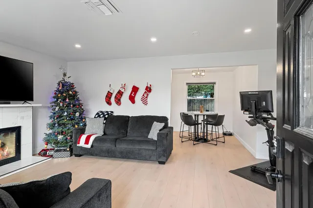 a living room with furniture a flat screen tv and a fireplace