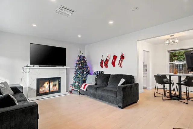 a living room with furniture a flat screen tv and a fireplace