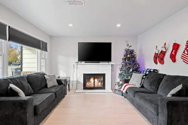 a living room with furniture a flat screen tv and a fireplace
