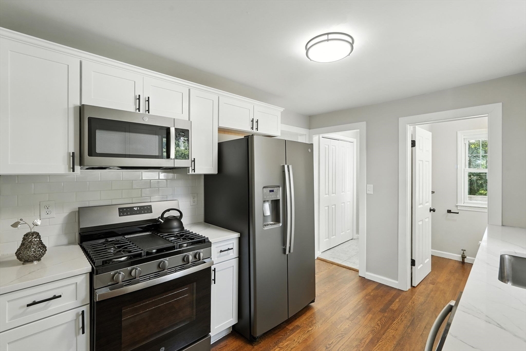 706 Allen Street Springfield, MA 01118 - Photo 15 of 33 a kitchen with stainless steel appliances a stove a microwave and a hard wood floors