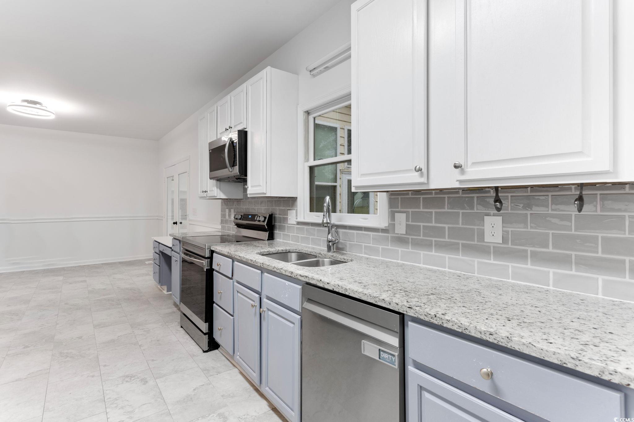 2321 Brick Drive Longs, SC 29568 - Photo 19 of 40 Kitchen with stainless steel appliances, backsplash, white cabinets, and light stone counters