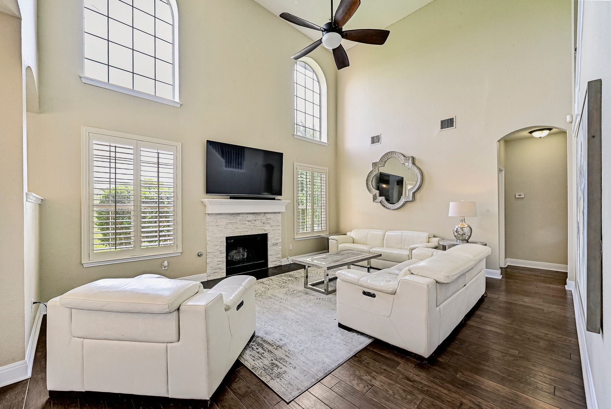 2408 Amen Corner Road Pflugerville, TX 78660 - Photo 9 of 40 Soaring ceilings define this living space, featuring wood-finish flooring and a contemporary ceiling fan