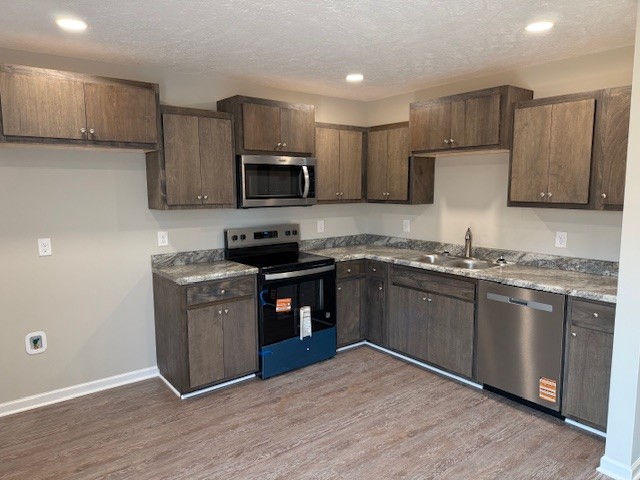 3336 Oak Grove Road Decherd, TN 37324 - Photo 7 of 21 a kitchen with granite countertop wooden floors and stainless steel appliances