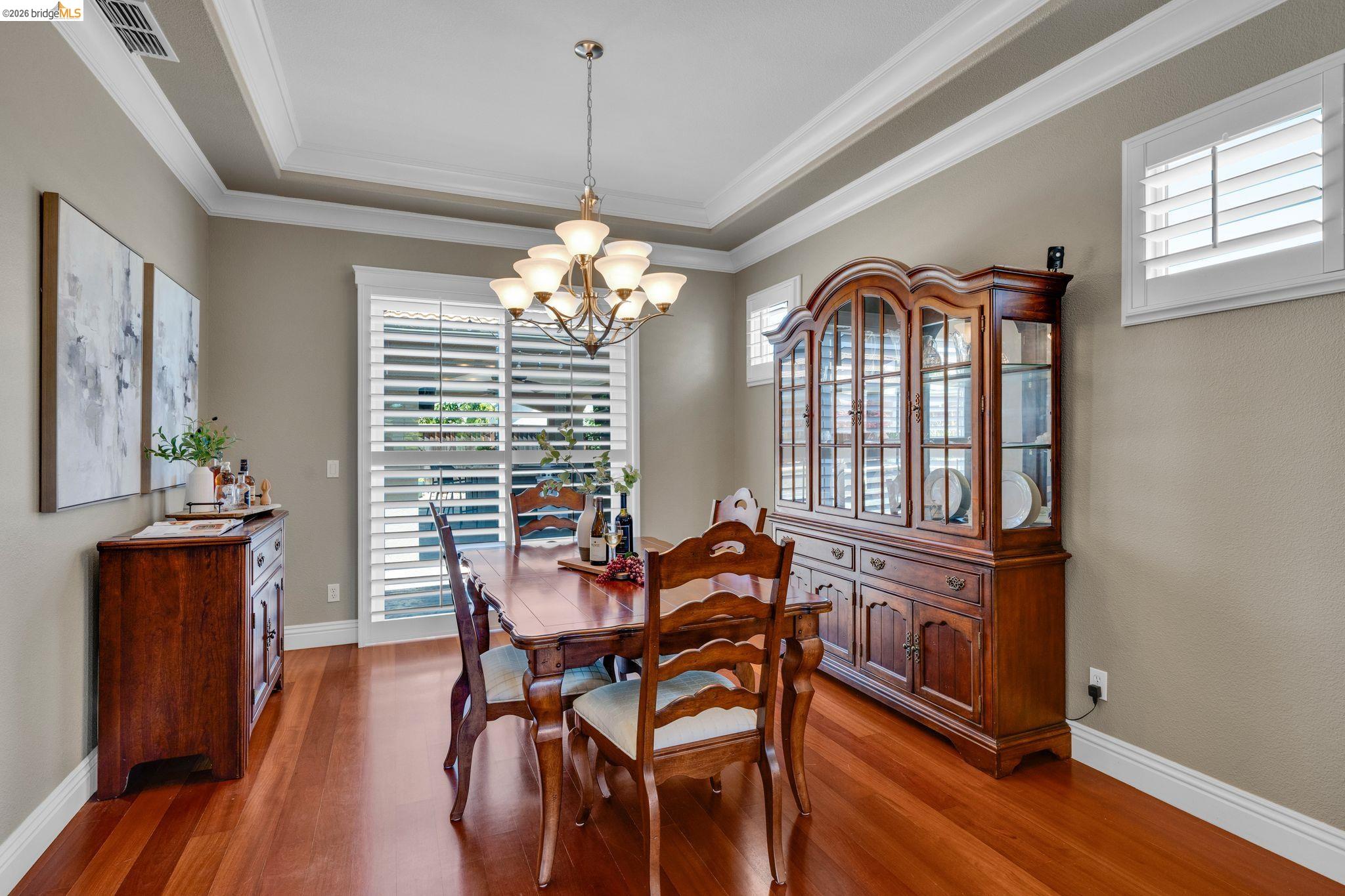 2513 Winged Foot Road Brentwood, CA 94513 - Photo 5 of 45 Dining area featuring warm wood-finish flooring and a tray ceiling with crown molding