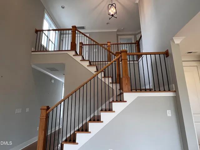 a view of staircase with lots of frames on wall and a window
