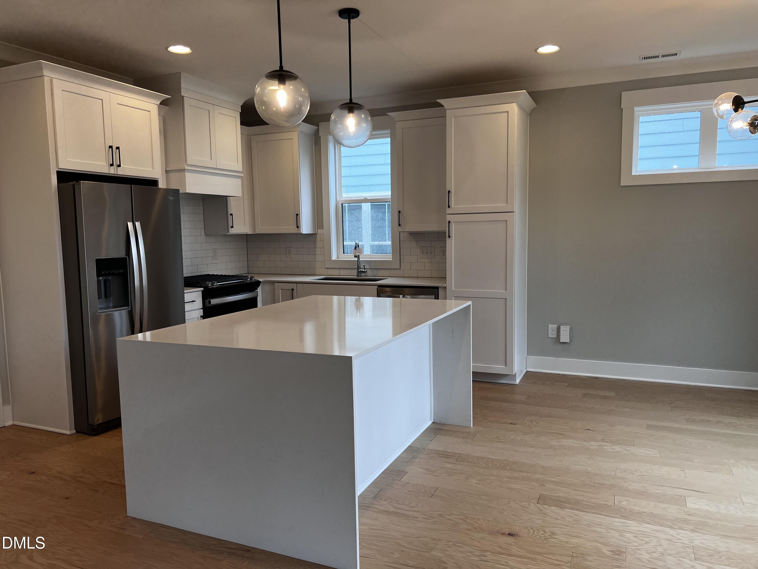 1439 Garner Road Raleigh, NC 27610 - Photo 3 of 28 a kitchen with stainless steel appliances granite countertop a refrigerator a oven a sink and white cabinets with wooden floor