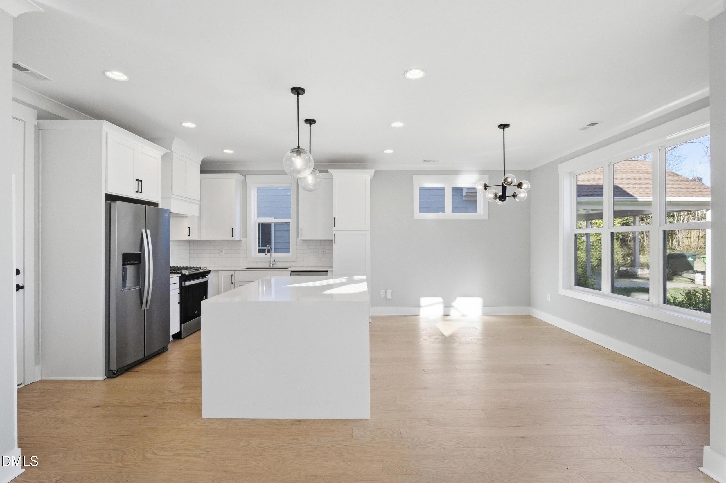 1439 Garner Road Raleigh, NC 27610 - Photo 4 of 37 a large kitchen with stainless steel appliances kitchen island a large counter top a refrigerator and a sink