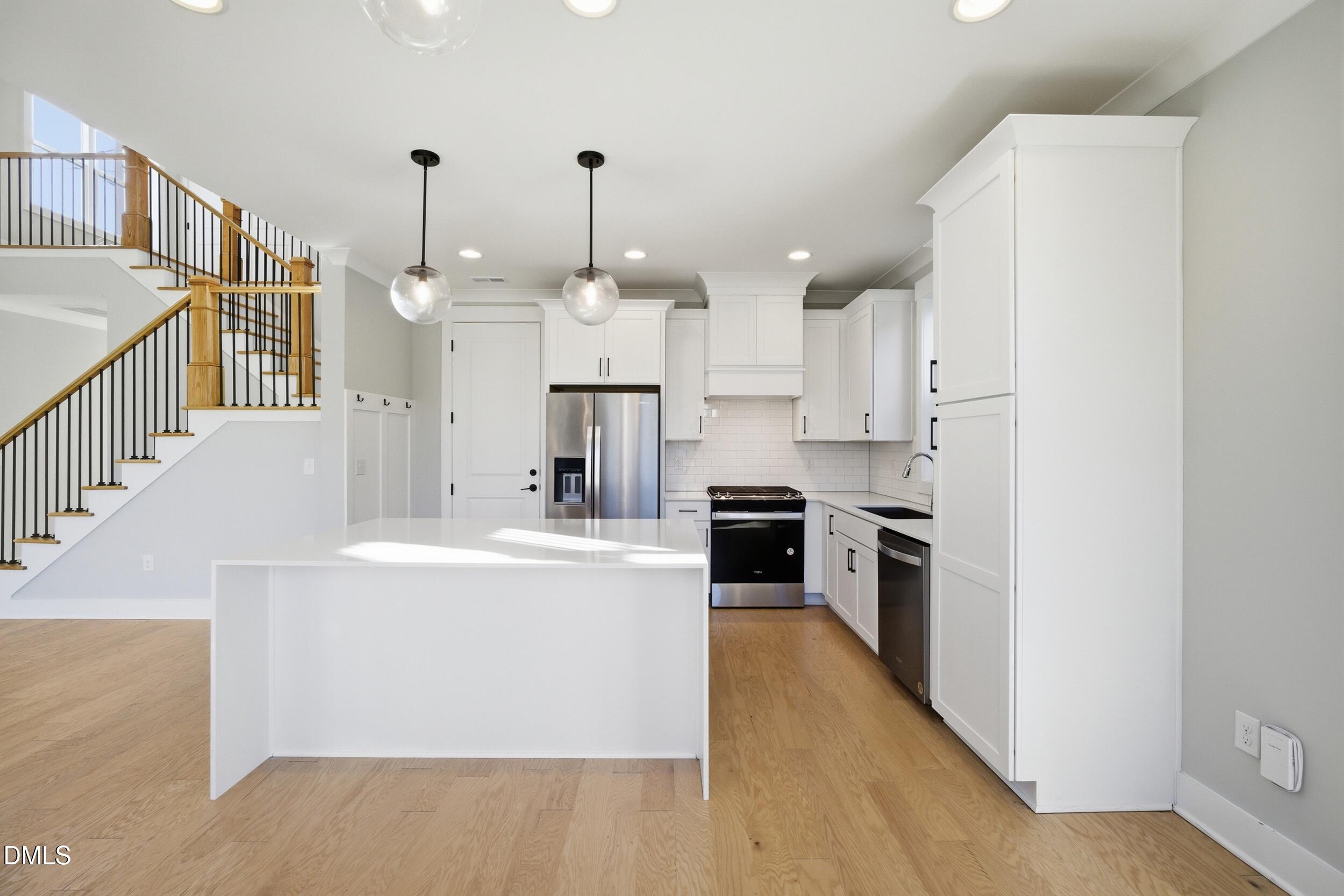 1439 Garner Road Raleigh, NC 27610 - Photo 5 of 37 a large white kitchen with stainless steel appliances