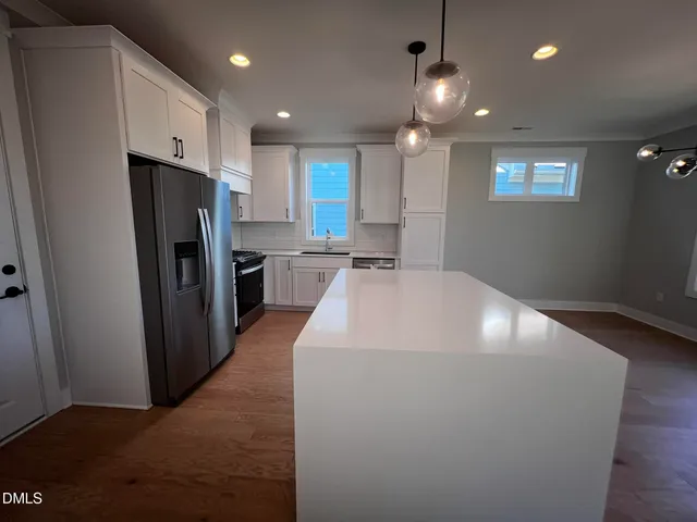 a large kitchen with stainless steel appliances a refrigerator and a stove