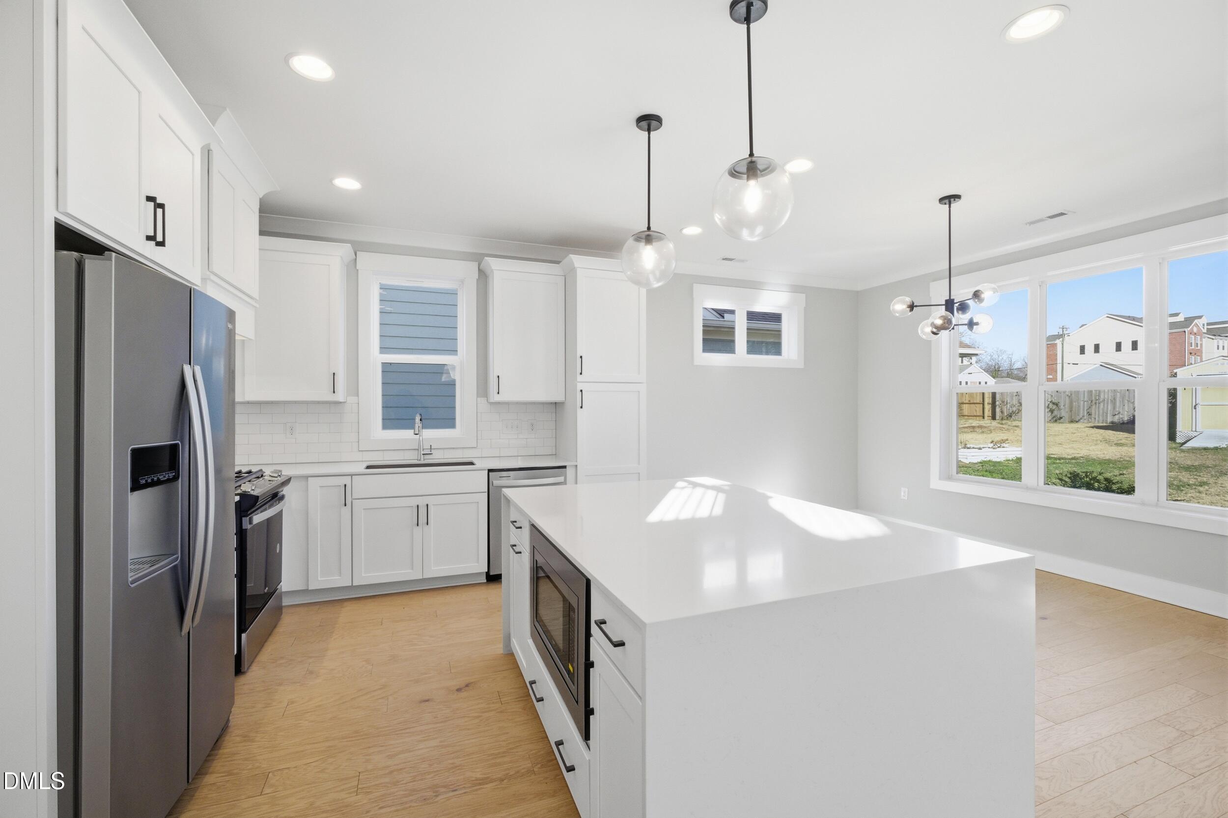 1439 Garner Road Raleigh, NC 27610 - Photo 6 of 37 a kitchen with a refrigerator a sink and dishwasher with wooden floor