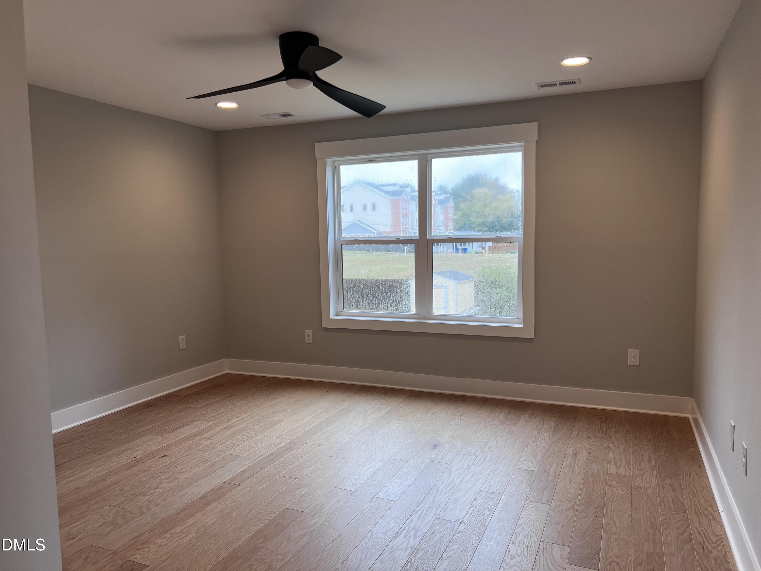 1439 Garner Road Raleigh, NC 27610 - Photo 9 of 28 a view of an empty room with wooden floor and a window