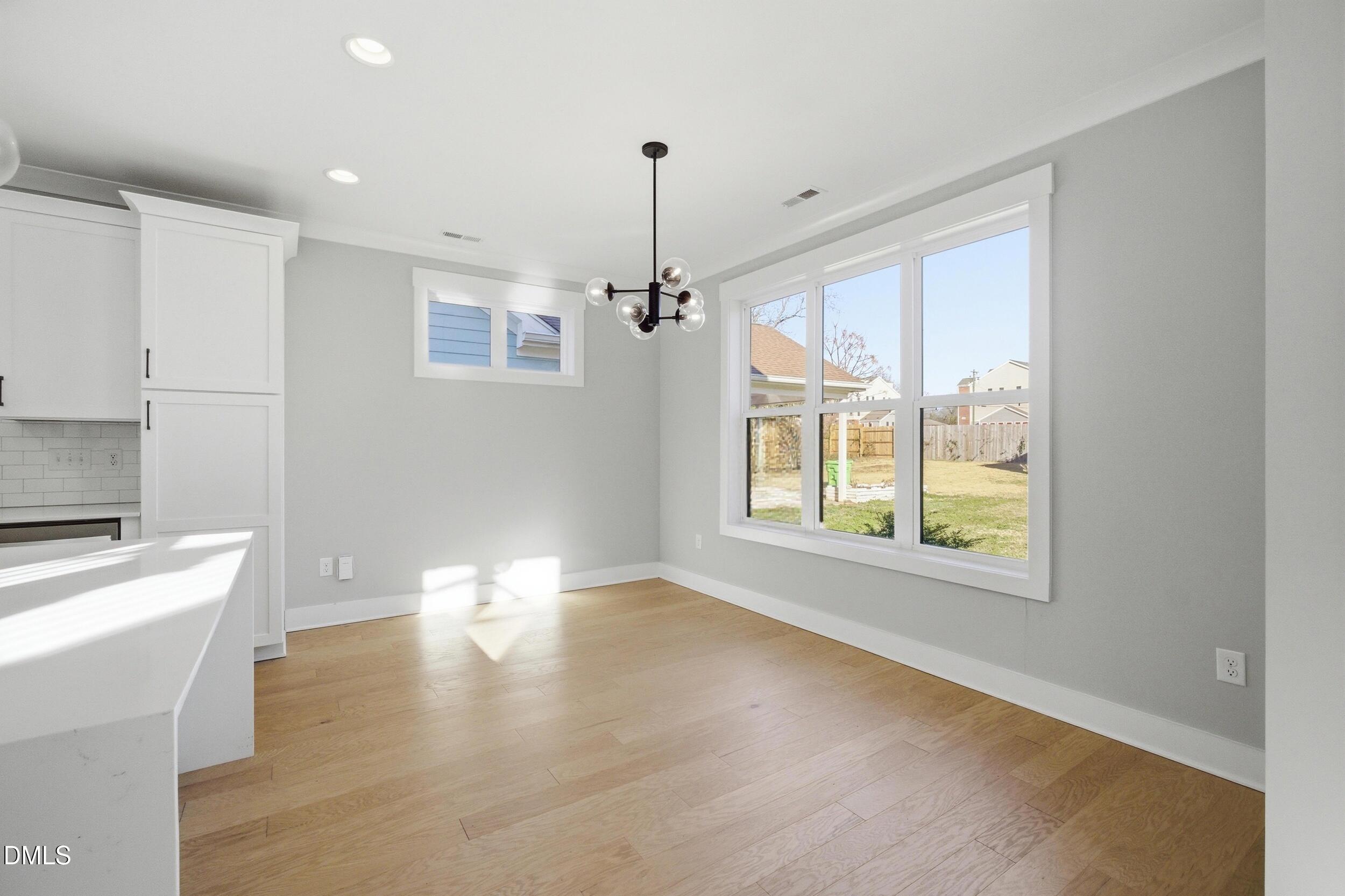 1439 Garner Road Raleigh, NC 27610 - Photo 10 of 37 a view of an empty room with a window and wooden floor