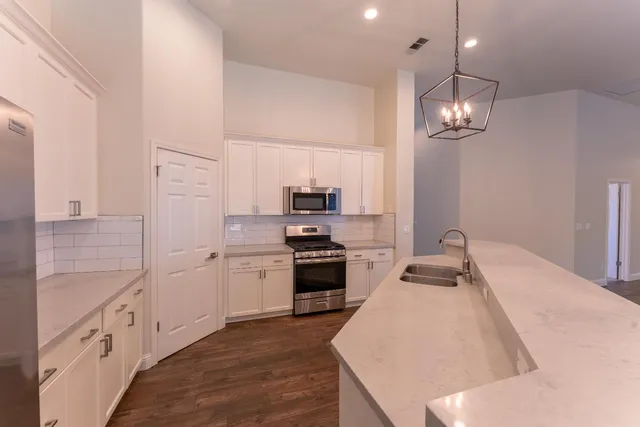 a kitchen with stove cabinets and stainless steel appliances