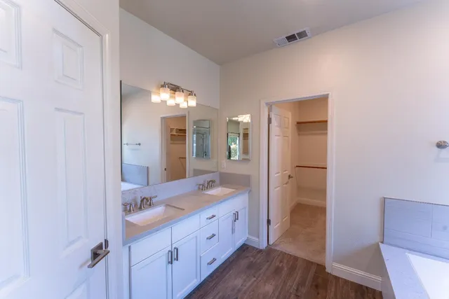 a spacious bathroom with a granite countertop sink mirror and a toilet