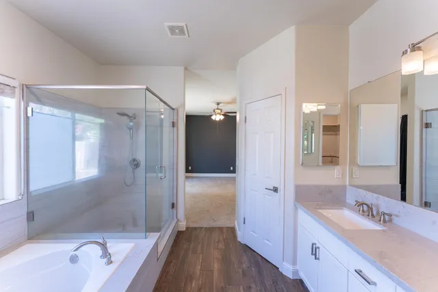 a bathroom with a tub sink shower and mirror