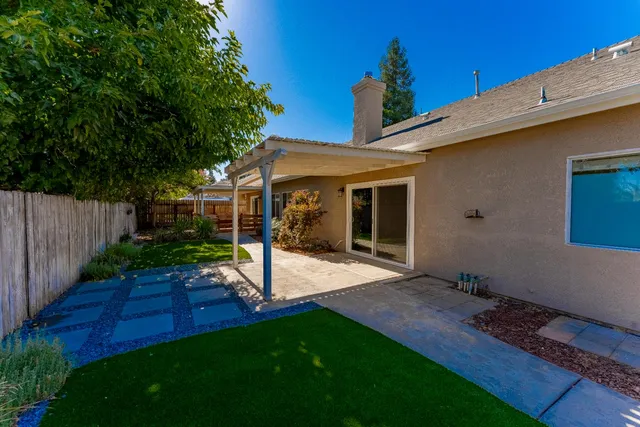 a view of a backyard with table and chairs with wooden fence