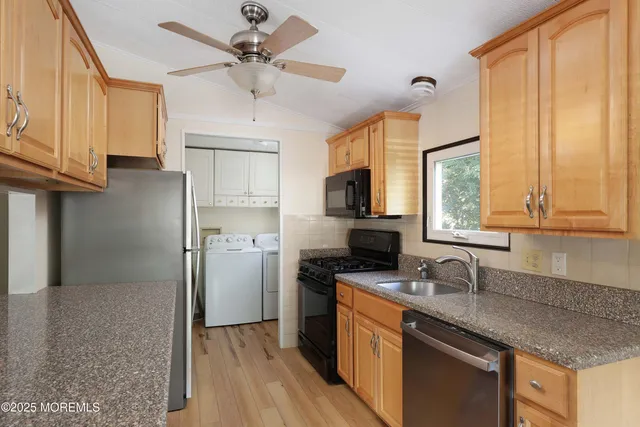 a kitchen with stainless steel appliances granite countertop a sink a stove and refrigerator