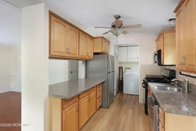 a kitchen with stainless steel appliances granite countertop a sink dishwasher stove top oven and refrigerator