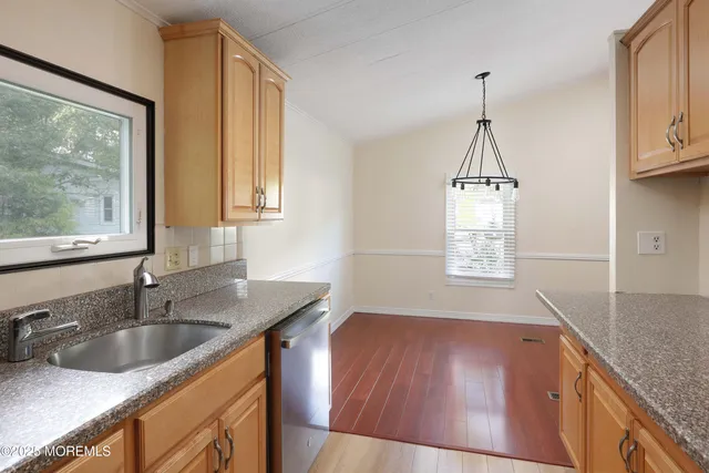 a kitchen with stainless steel appliances granite countertop a sink a window and cabinets