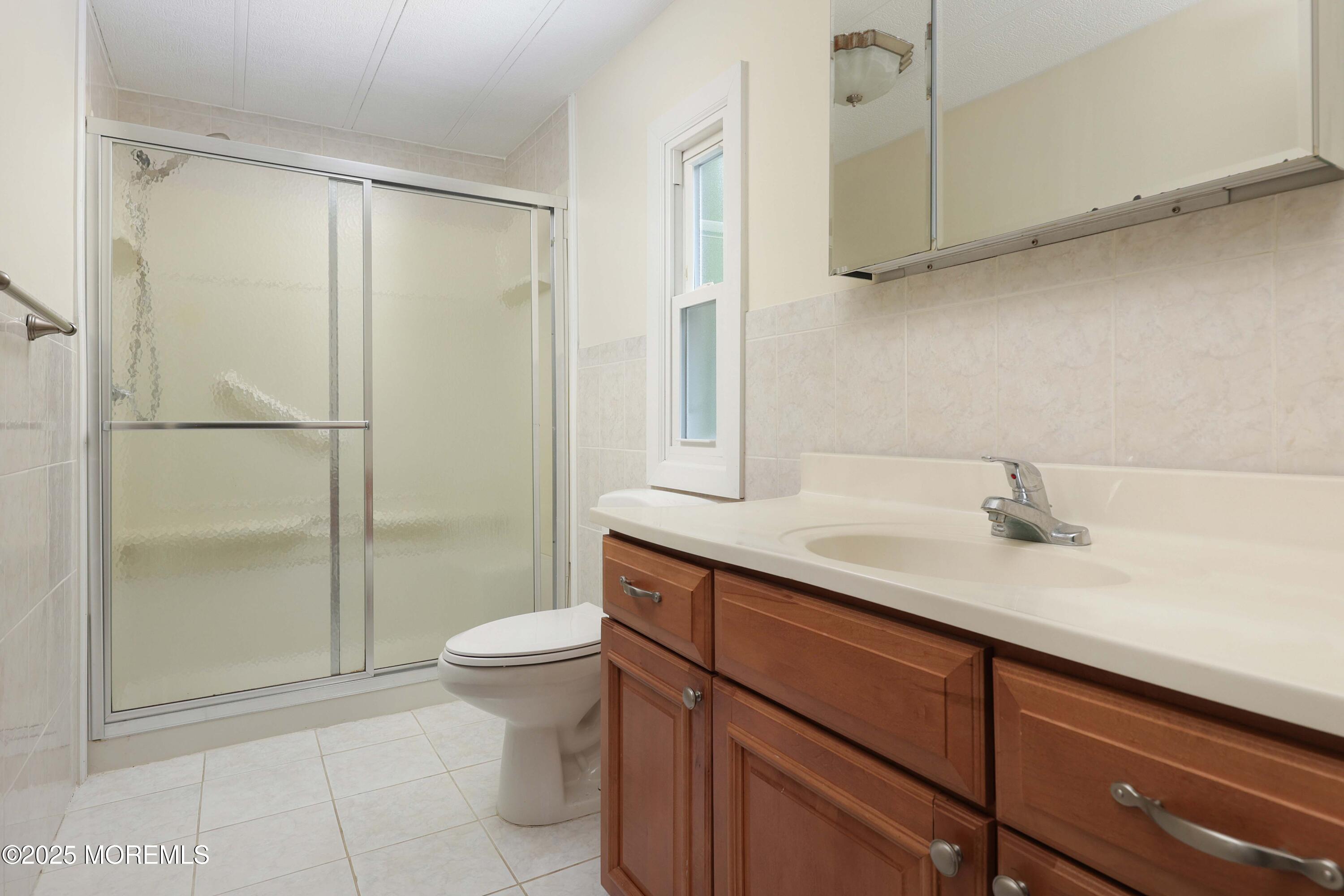 15 Cedar Court Manalapan, NJ 07726 - Photo 29 of 30 a bathroom with a sink a toilet and shower