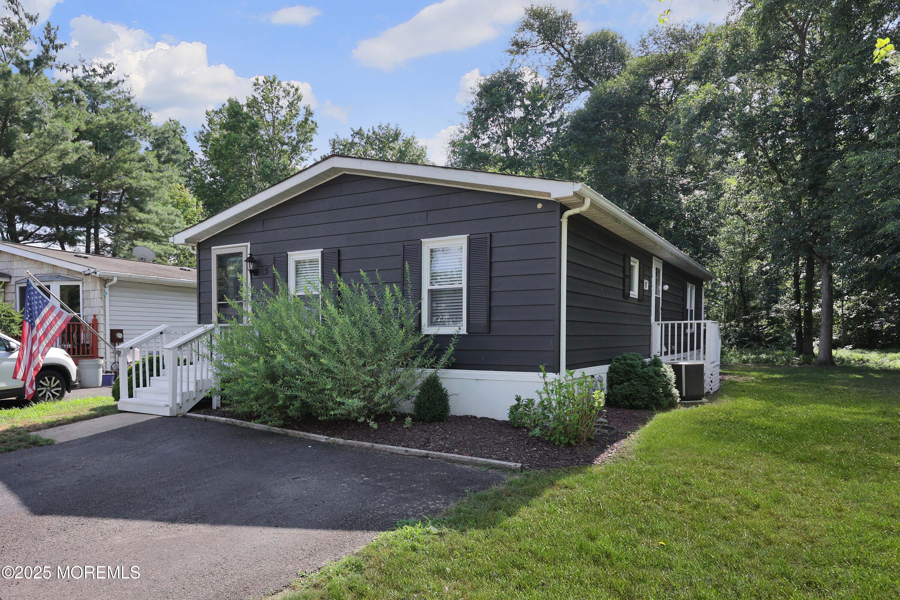 15 Cedar Court Manalapan, NJ 07726 - Photo 3 of 30 a front view of a house with a yard and garage