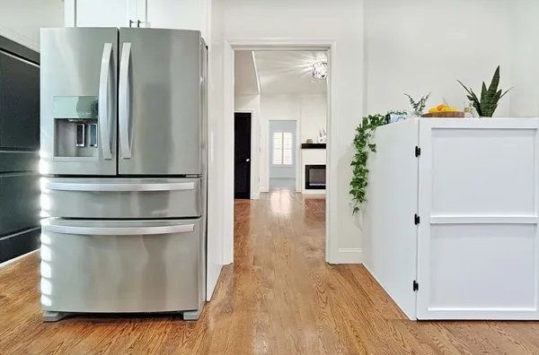 a kitchen with stainless steel appliances a refrigerator and a hard wood floor