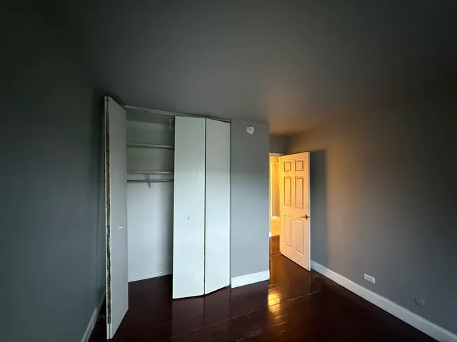 an empty room with wooden floor and a window
