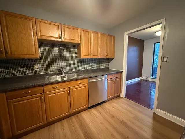 a kitchen with granite countertop wooden cabinets stainless steel appliances a sink and a window