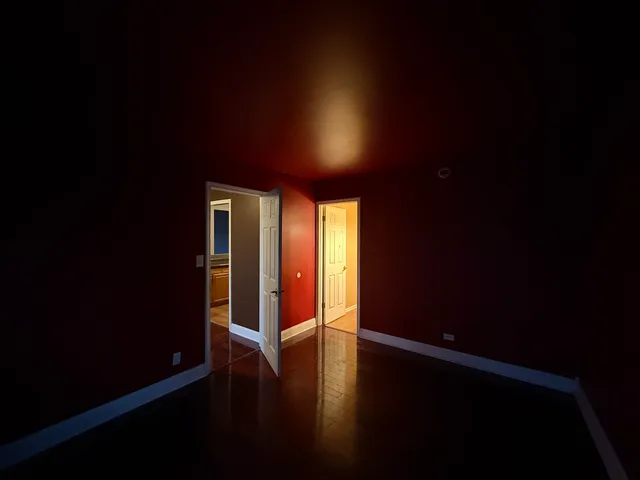 a empty room with wooden floor and windows