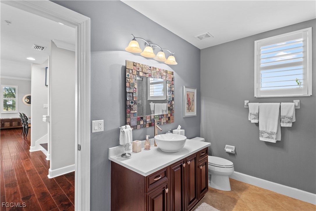 1104 6th Street South, Unit 1 Naples, FL 34102 - Photo 28 of 47 a bathroom with a sink a toilet and a mirror