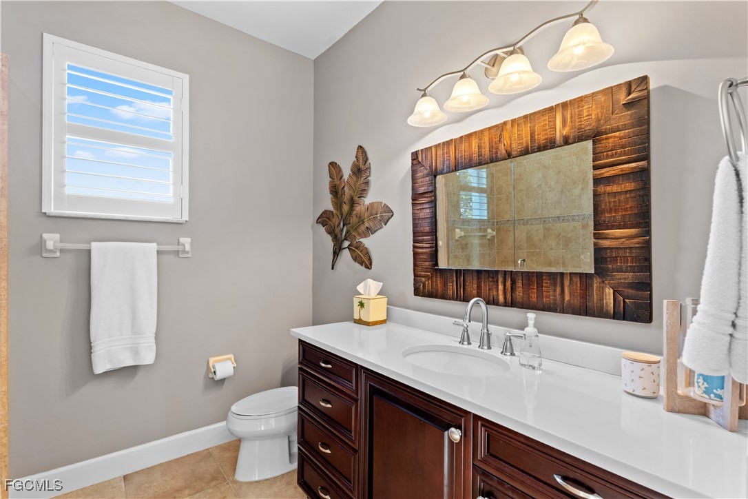 1104 6th Street South, Unit 1 Naples, FL 34102 - Photo 43 of 47 a bathroom with a granite countertop sink mirror and toilet