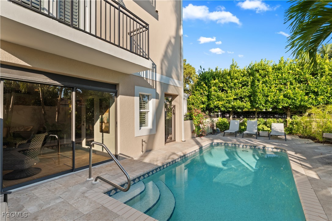 1104 6th Street South, Unit 1 Naples, FL 34102 - Photo 9 of 47 a swimming pool with outdoor seating and yard
