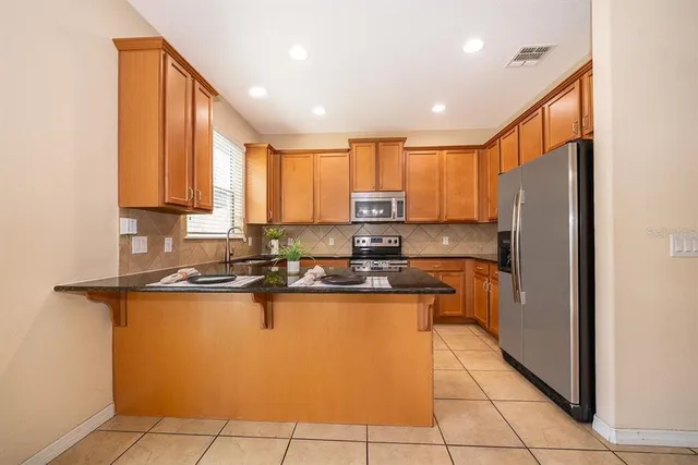 a kitchen with stainless steel appliances granite countertop a refrigerator sink and cabinets